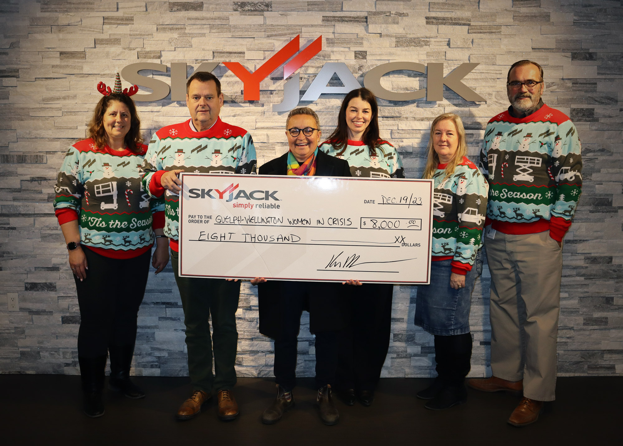 Skyjack and GWWIC members posing with the cheque in the Christmas Sweaters