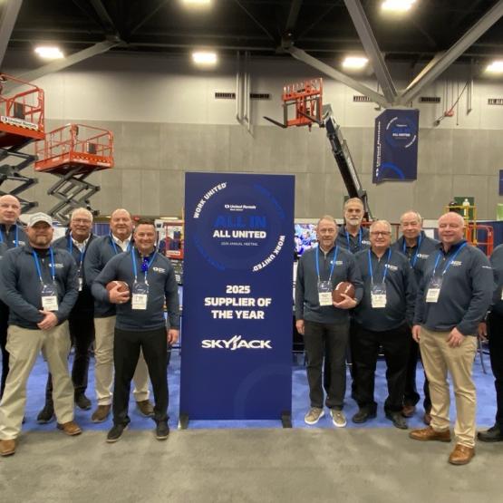 Skyjack team with United Rentals Supplier of the Year Banner at tradeshow booth.
